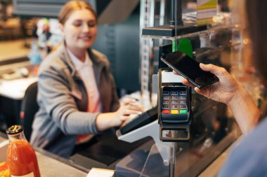 Markette telefonla ödeme yapan tanınmamış bir kadın.