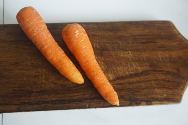 Beyaz arka planda tahtadan yapılmış taze havuçlar.