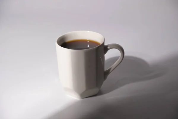 shot of white coffee mug with shadow on white background