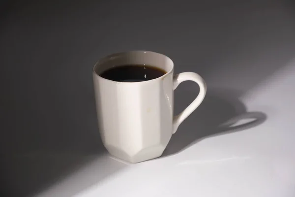shot of white coffee mug with shadow on white background