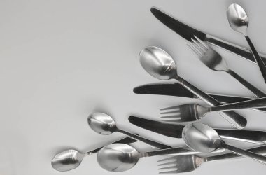Cutlery, forks, knives, and spoons on a white background