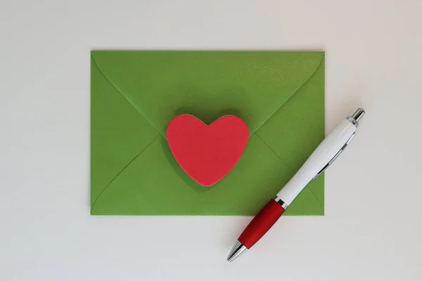 Green letter envelope with red heart and pen