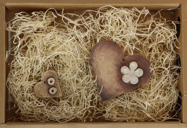Ceramic hearts in paper box with straw