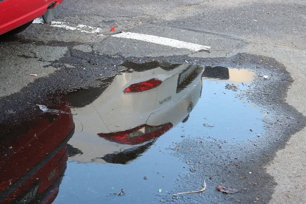 Odbicie Samochodu Kałuży Ulicy Deszczu — Zdjęcie stockowe