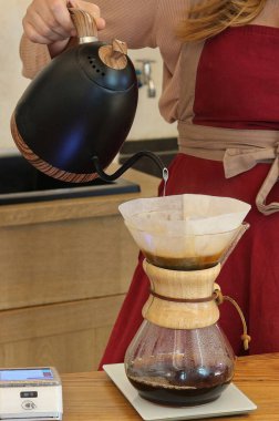 Kafedeki barista damlayan kahveyi hazırlar.