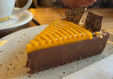 Kafenin masasında mangolu çikolatalı pasta.