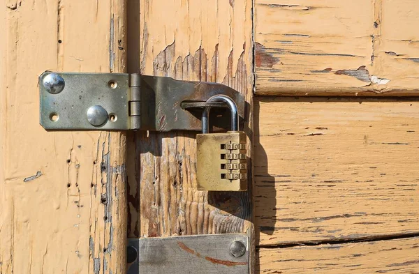 padlock with numeric code with hasp on old chipped door