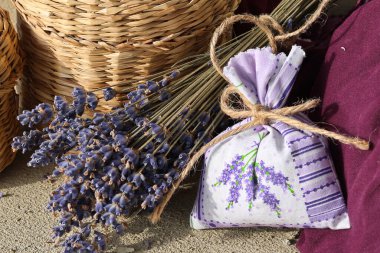Bir demet kurutulmuş lavanta ve kurutulmuş otlu bez torbası.