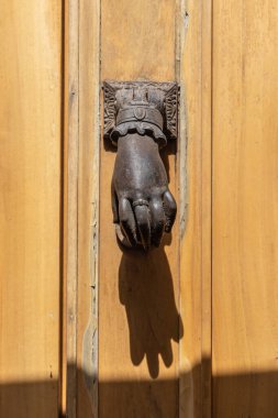 Aigues-Mortes, Gard, Occitania, France. Old metal door knocker in the shape of a hand.