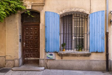 Arles, Bouches-du-Rhone, Provence-Alpes-Cote d'Azur, France. Blue painted shutters on an iron barred window.