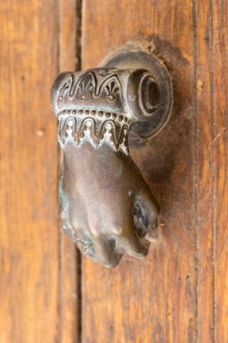 Arles, Bouches-du-Rhone, Provence-Alpes-Cote d'Azur, France. An old brass door knocker in the shape of a hand.