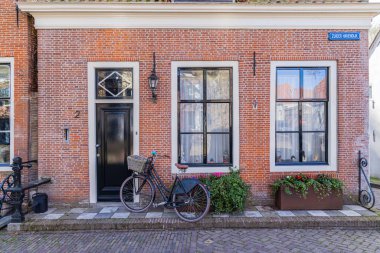 Avrupa, Hollanda, Kuzey Hollanda, Enkhuizen. 24 Nisan 2022. Bisikletle tuğla bir evin önünde.