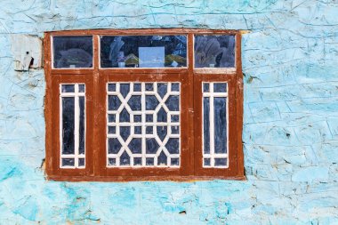 Kangan, Jammu ve Kashmir, Hindistan. Jammu ve Kashmir 'de mavi bir evde ahşap çerçeveli bir pencere..