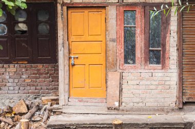 Rainawari, Srinagar, Jammu ve Kashmir, Hindistan. Srinagar 'da tuğladan bir evde sarı kapı..