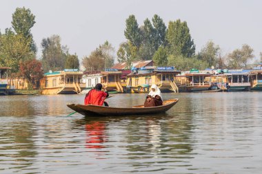 Dal Gölü, Rainawari, Srinagar, Jammu ve Kashmir, Hindistan. 25 Ekim 2022. Kadınlar Dal Gölü 'nde geleneksel bir teknede kürek çekiyorlar..