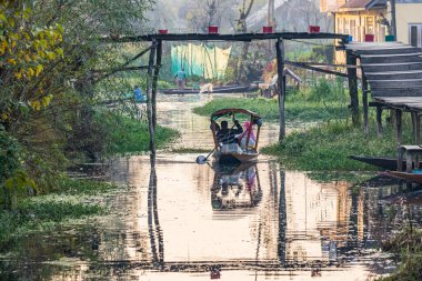 Rainawari, Srinagar, Jammu ve Kashmir, Hindistan. 25 Ekim 2022. Bir adam Dal Gölü 'nde geleneksel bir teknede kürek çekiyor..