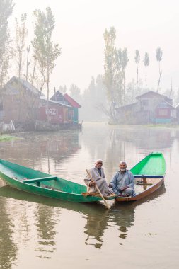 Dal Gölü, Rainawari, Srinagar, Jammu ve Kaşmir, Hindistan. 26 Ekim 2022. Dal Gölü 'ndeki geleneksel teknelerdeki adamlar.