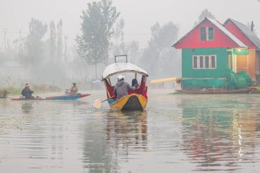 Dal Gölü, Rainawari, Srinagar, Jammu ve Kaşmir, Hindistan. 26 Ekim 2022. Sisin içinde Dal Gölü 'nde kürek çeken bir adam.