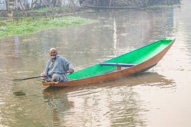 Dal Gölü, Rainawari, Srinagar, Jammu ve Kaşmir, Hindistan. 26 Ekim 2022. Dal Gölü 'nde geleneksel bir teknedeki adam.