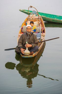 Dal Lake, Srinagar, Jammu ve Kashmir, Hindistan. 26 Ekim 2022. Dal Gölü 'nde su piposu içen bir adam..
