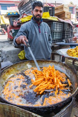 Berna Bugh, Kangan, Jammu ve Kashmir, Hindistan. 27 Ekim 2022. Jammu ve Kashmir köyündeki bir markette satılık abur cubur kızartıyorum..