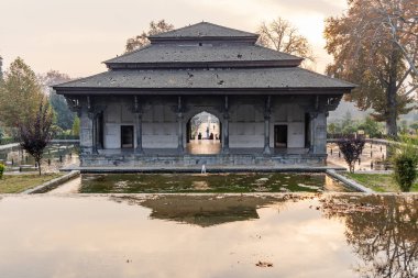 Srinagar, Jammu ve Kashmir, Hindistan. 30 Ekim 2022. Babür Bahçesi 'ndeki bir gölette taş bina..