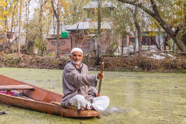Rainawari, Srinagar, Jammu ve Kashmir, Hindistan. 1 Kasım 2022. Adam Dal Gölü 'nde geleneksel bir teknede kürek çekiyor..