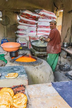 Rainawari, Srinagar, Jammu ve Kashmir, Hindistan. 1 Kasım 2022. Baker geleneksel ahşap fırını kullanıyor..