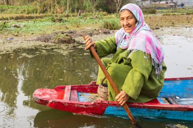 Rainawari, Srinagar, Jammu ve Kashmir, Hindistan. 2 Kasım 2022. Dal Gölü 'nde geleneksel bir teknede kürek çeken kadın..