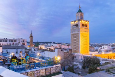 Medina, Tunis, Tunisia. March 10, 2023. Rooftop cafe overlooking the Great Mosque in the Medina of Tunis. clipart