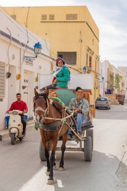 Kairouan, Tunus. 14 Mart 2023. Kairouan şehrinde mobilya taşımak için at arabası kullanmak..