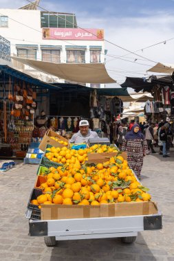 Kairouan, Tunus. 14 Mart 2023. Kairouan çarşısında portakal arabası süren bir adam..