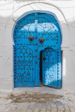 Tunus, Tunus. Tunus Çarşısı 'nın yakınındaki bir evin mavi bir anahtar deliği ya da Mağripli kemer kapısı..