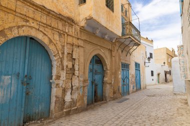 Kairouan, Tunus. Kairouan şehrinde bir sokak boyunca uzanan mavi kapılar..