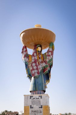 Chott el Djerid, Tozeur, Tunus. 18 Mart 2023. Chott el Djerid kuru tuz gölünde büyük bir tava taşıyan bir kadın heykeli..