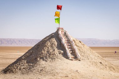 Chott el Djerid, Tozeur, Tunus. Chott el Djerid 'de bir tepecikte bayraklar kuru tuz gölünde.