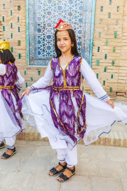 Khiva, Xorazm Bölgesi, Özbekistan, Orta Asya. 22 Ağustos 2021. Khiva 'daki geleneksel Özbek müzik grubunda çocuk dansçı.
