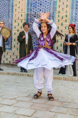 Khiva, Xorazm Bölgesi, Özbekistan, Orta Asya. 22 Ağustos 2021. Khiva 'daki geleneksel Özbek müzik grubunda çocuk dansçı.