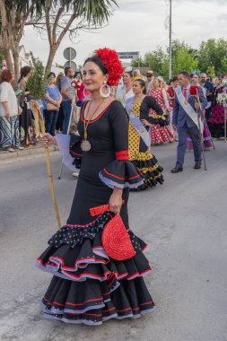 Andujar, Jaen Eyaleti, Endülüs, İspanya. 28 Nisan 2023. Geleneksel elbiseli kadın Andujar 'da dini bir festivalde geçit töreninde yürüyor..