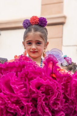 Andujar, Jaen Eyaleti, Endülüs, İspanya. 29 Nisan 2023. Andujar 'daki bayram sırasında renkli geleneksel elbiseli bir kız..