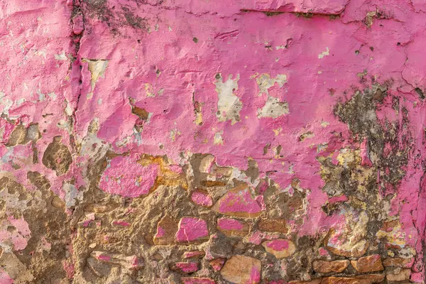 stock image Devnagar, Ajmer, Rajasthan, India. Peeling pink stucco on a rock wall.