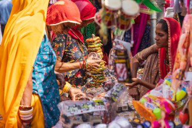 Pushkar, Rajasthan, Hindistan. 6 Kasım 2022. Açık hava pazarında bilezik alışverişi yapan kadınlar..