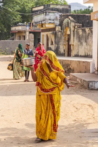 Devnagar, Ajmer, Rajasthan, Hindistan. 8 Kasım 2022. Sarı elbiseli kadın Rajasthan caddesinde yürüyor..