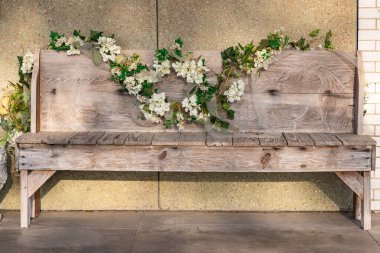 Yoakum, Teksas, Birleşik Devletler. Yapay çiçekler ahşap bir bankı süslüyor..