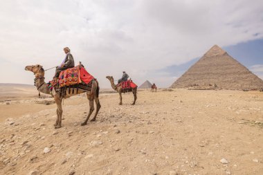 Giza Piramit Kompleksi, Al Ahram, Giza, Mısır. 22 Şubat 2023. Khafre Piramidinin önünde develi adamlar.