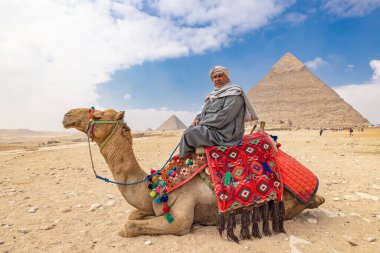 Giza Piramit Kompleksi, Al Ahram, Giza, Mısır. 22 Şubat 2023. Khafre Piramidinin önündeki devenin üzerindeki adam..