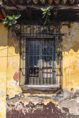 Antigua Guatemala, Sacatepequez, Guatemala. Boya soymak ve eski bir evin parmaklıklı penceresi..