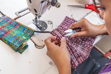 Santa Cruz La Laguna, Solola, Guatemala. Crafts person working with traditional Guatemalan woven cloth. clipart