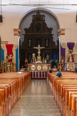 Santiago Atitlan, Solola, Guatemala. March 13, 2024. Pews and the altar in the nave in the Church of Saint James the Apostle in Santiago Atitlan. clipart