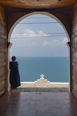 San Antonio Palopo, Solola, Guatemala. March 14, 2024. Woman looking over Lake Atitlan from the San Antonio Palopo Church. clipart